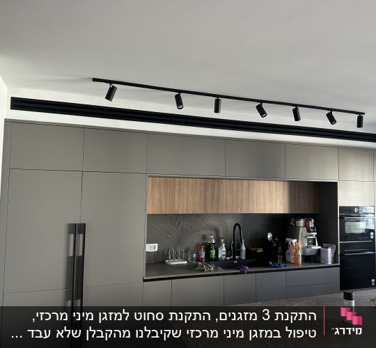 מטבח מודרני עם ארונות, כיור ומכשירי חשמל.
